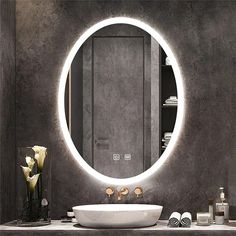 a bathroom with a round mirror above the sink