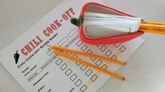 two pencils are sitting in a cup on top of a paper with the word grill cook off