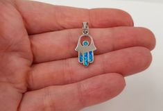 "This beautiful Hamsa Hand pendant is hand crafted from 925 Sterling Silver. At the heart of pendant energetic blue Opal gemstone. 💖 Ideal Gift: Comes with an elegant gift pouch. A perfect gift for women, men, friend, loved one, mother, and so on. Can be used in birthday, bat / bar mitzvah, wedding, anniversary, Holidays or any special occasion. About Hamsa Amulet:  Sometimes referred to as the \"Hand of God\", Hamsa amulets are some of the most popular charms available. These amulets are belie Turquoise Opal Jewelry As A Gift, Turquoise Stainless Steel Jewelry As A Gift, Turquoise Stainless Steel Jewelry As Gift, Symbolic Blue Jewelry For Gift, Symbolic Blue Jewelry As Gift, Turquoise Opal Jewelry As Gift, Turquoise Stainless Steel Jewelry Gift, Symbolic Blue Jewelry For Gifts, Blue Stainless Steel Necklace Ideal For Gift