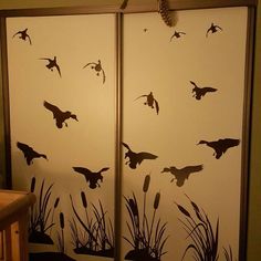 the birds are flying over the water and reeds on the wall in the room