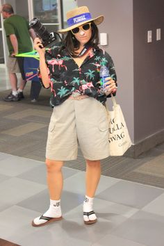 a woman is taking a selfie with her camera in an airport lobby while wearing shorts and a hat