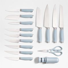 a collection of kitchen knives and utensils on a white surface