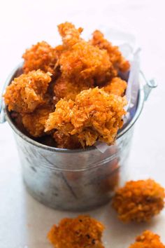 a bucket filled with fried food sitting on top of a table