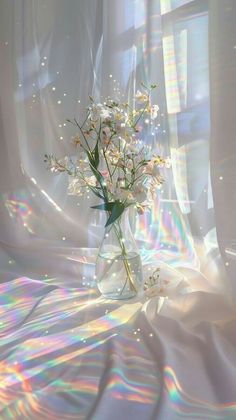 a vase filled with white flowers sitting on top of a bed next to a window