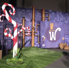 a fake candy cane tree in front of a wall with the w logo on it