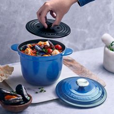 a blue pot filled with food on top of a table