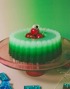 there is a cake with cherries on top and green icing in the middle