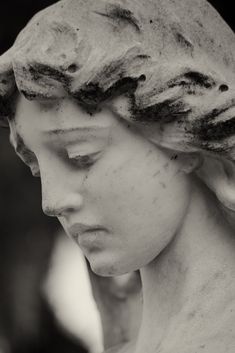 a close up of a statue with hair on it's head and eyes closed