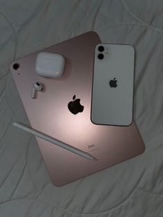 two iphones sitting on top of each other next to an apple pencil and headphones