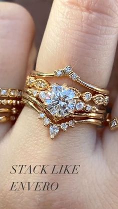 a close up of a person's hand with two wedding rings on their fingers