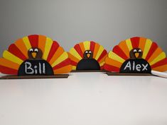 three wooden turkeys with the words bill and alex painted on them, sitting next to each other