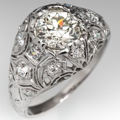 Circa 1920s domed ring features a pierced design and is centered with one (1) old European cut diamond weighing 0.95 carat and set with four-prongs. The ring is accented with fourteen (14), bead set, old European/single cut diamonds. The ring measures 11.7mm at the top, rises 5.5mm above the finger, tapering to 1.7mm wide and 1.0mm thick at the base of the shank. This ring is currently a size 5.25 and we offer complimentary resizing to fit. Classic Domed Diamond Ring, Classic Platinum Dome Ring, Classic Diamond Dome Ring With Round Cut, Classic White Gold Platinum Dome Ring, Wedding Vvs Clarity Round Dome Ring, Classic White Gold Dome Ring In Platinum, Classic Dome Ring With Diamond Cut, Classic Dome Ring With Center Stone For Anniversary, Heirloom Dome Ring With Single Cut Diamonds