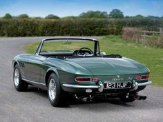 a green sports car parked on the side of a road