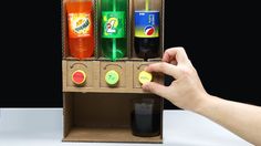 a hand is holding an open cardboard box with drinks in it