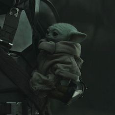 a baby yoda in a star wars costume holding onto a backpack with the force awake logo on it