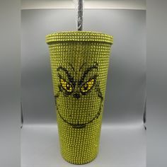 a yellow trash can with a face made out of plastic beads on the front and sides