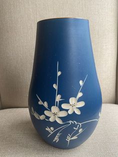 a blue vase with white flowers painted on it