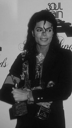 michael jackson holding two awards in his hands