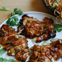 some chicken wings are on a plate with noodles