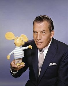 a man in a suit holding a stuffed mouse