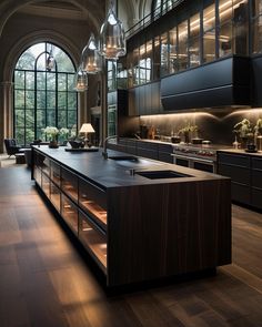 a large kitchen with lots of counter space and lights hanging from the ceiling above it