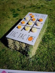 an advertisement for tic tac toe with pumpkins on the board and hay