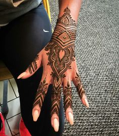 a woman's hand with henna tattoos on it