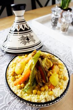 a plate with rice and vegetables on it next to a potted plant in a vase