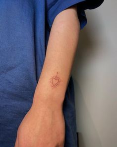 a person with a heart tattoo on their arm