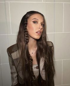 a mannequin head with long hair in front of a white tiled bathroom wall