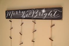 a sign that says merry and bright hanging on the wall next to some clothes pins