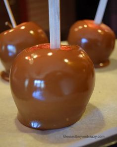 three chocolate covered apples with toothpicks sticking out of them on a counter top