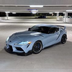 a blue toyota sports car parked in a parking garage with no one around it,