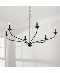 a black chandelier hanging from the ceiling in a room with white walls and windows