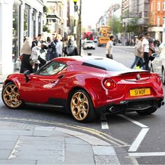 a red sports car driving down the street