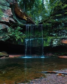 a small waterfall in the middle of a forest