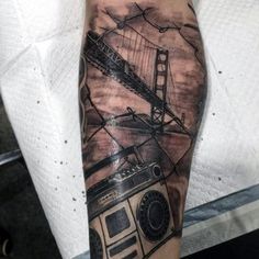 a man's arm with an old fashion radio and the golden gate bridge on it