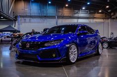 a blue car parked in a garage next to other cars