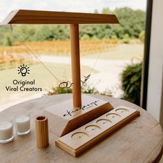 a wooden table with two candles and an object on it that says original virtual creations