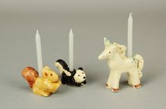 three small figurines with candles in the shape of animals