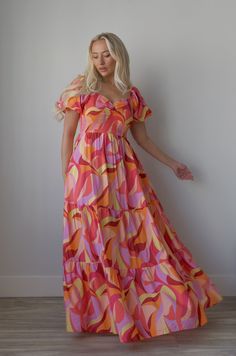 Experience the perfect blend of comfort and style with our vibrant Multicolor Printed Maxi Dress. The smocked bust and short puff sleeves provide a flattering fit while the geometric pattern print adds a touch of uniqueness. Complete with a tiered design, this dress is perfect for any occasion. puff sleeves maxi length colorful (pink, orange, purple, red) smocked bodice tiered pockets lined 85% rayon 15% nylon hand wash cold or on delicate cycle model is wearing a small Multicolor Smocked Bodice Short Sleeve Dress, Pink Short Sleeve Dress With Abstract Print, Multicolor Short Sleeve Dress With Smocked Bodice, Summer Multicolor Puff Sleeve Maxi Dress, Multicolor Short Sleeve Dress With Geometric Pattern, Multicolor Geometric Pattern Short Sleeve Dresses, Curvy Date Night Outfit, Air Clothes, Puff Sleeve Maxi Dress