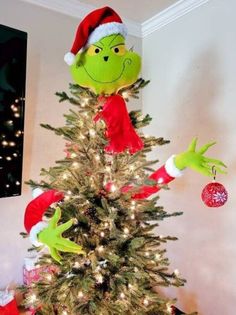 a christmas tree decorated with the grin's head and hands on top of it