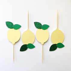 three popsicles with green leaves and lemons cut out of them on a white background