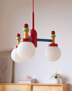 two red and green lights hanging from a ceiling fixture in a room with white walls