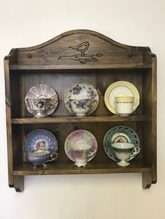 a wooden shelf with plates and cups on it