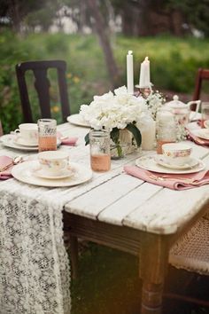 the table is set with plates, cups and saucers