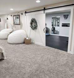 a bedroom with two white bean bags on the floor and an open door leading to another room