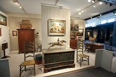 a room filled with furniture and pictures on the walls, including an antique cabinet in the center