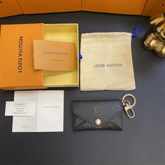 the louis vuitton wallet is in its box and it's contents are on the table