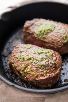 two steaks are cooking in a skillet